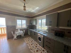 a large kitchen with a washing machine in it at Appartement à Houma, proche Port Tanger Med in Dalia
