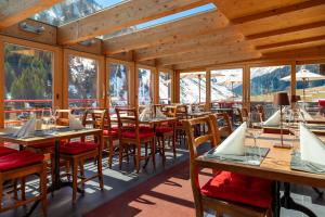 a restaurant with tables and chairs with mountains in the background at Gasthaus Rheinwaldstube in Nufenen