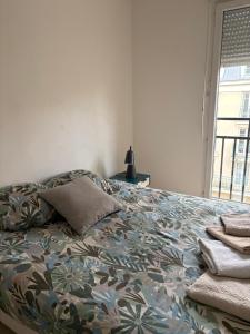 a bedroom with a bed with a blanket and a window at Disneyland Family and Friends great location apart in Chessy