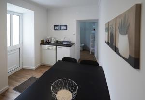 a dining room with a table and a kitchen at Casa do Negrão in Ponta Delgada