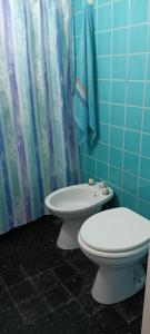 a bathroom with a toilet and a shower curtain at Monis House in Buenos Aires