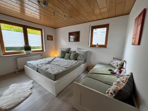 a bedroom with two beds and a couch in it at Großzügige Ferienwohnung im Remstal in Korb