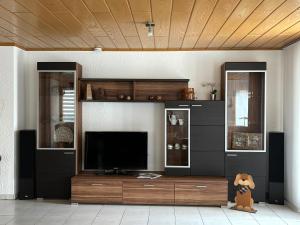 a living room with a large entertainment center with a television at Großzügige Ferienwohnung im Remstal in Korb