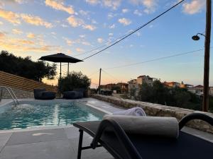 una piscina con una silla y una sombrilla en Villa Maria, en Stalós