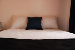 a bed with a black and white pillow on it at Casa Don Quijote in Concepción de Ataco