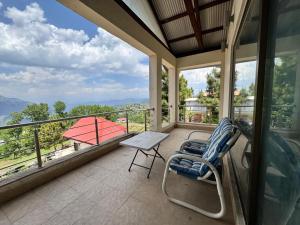 un balcon avec une table et des chaises et une vue dans l'établissement Haven Resort Bhurban, Murree, à Bhurban