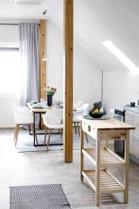 eine Küche und ein Esszimmer mit Tisch und Stühlen in der Unterkunft Egy présház tágas tetőtere mesés kilátással in Hegymagas