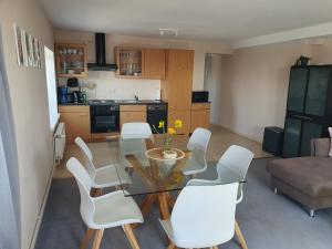 a living room with a glass table and white chairs at Neumühler Hof- Ferienwohnung "Thomas" 3 Zimmer,3 Bäder mit Dusche, kostenfreie Parkplätze vor dem Haus in Schwerin