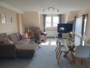 a living room with a couch and a glass table at Neumühler Hof- Ferienwohnung "Thomas" 3 Zimmer,3 Bäder mit Dusche, kostenfreie Parkplätze vor dem Haus in Schwerin