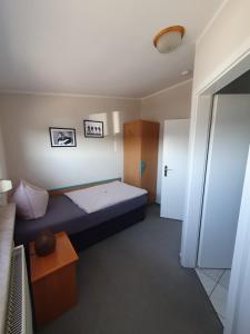 a small room with a bed and a refrigerator at Neumühler Hof- Ferienwohnung "Thomas" 3 Zimmer,3 Bäder mit Dusche, kostenfreie Parkplätze vor dem Haus in Schwerin