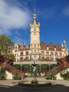 a building with a water fountain in front of it at Neumühler Hof- Ferienwohnung "Thomas" 3 Zimmer,3 Bäder mit Dusche, kostenfreie Parkplätze vor dem Haus in Schwerin