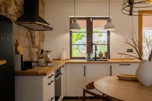 a kitchen with white cabinets and a table and a window at O Rio Da Meiga in Beloso