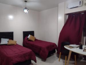 Habitación con 2 camas y mesa con mesa. en Obelisco full, en Buenos Aires