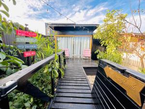 Una pasarela de madera que conduce a un jardín con una casa. en Mini Refugios Lodge, en Constitución
