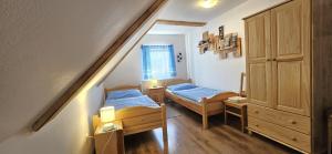 切尔尼杜尔Chalupa Čistá v Krkonoších 8的小房间设有两张床和楼梯 更多21张照片