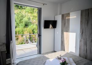 a dining room with a table and a sliding glass door at Ionian Pearl in Dhërmi