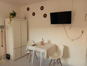 a white dining room with a white table and chairs at El rincón de boedo in Buenos Aires