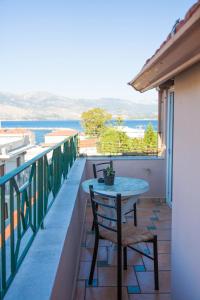 a patio with a table and chairs on a balcony at Dreamy Loft apartment Lixouri in Lixouri