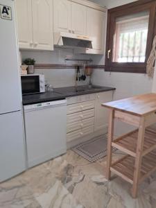 a kitchen with a white refrigerator and a table at La caracola in Novo Sancti Petri