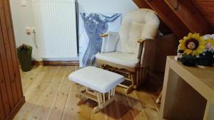 a living room with a white chair and a stool at Dreamy Loft apartment Lixouri in Lixouri