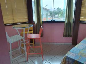 a small table and chairs in a room with a window at quarto duplo in Caraguatatuba