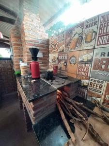 a counter in a room with a wall of beer signs at Estância arco iris in Regente Feijó