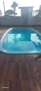 a swimming pool with blue water in a house at Estância arco iris in Regente Feijó