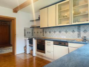 a kitchen with white cabinets and a stove top oven at Ferienwohnung Bina in Bad Feilnbach