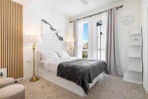 a white bedroom with a bed and a window at Squire - Prime Location with View & Parking in Seattle