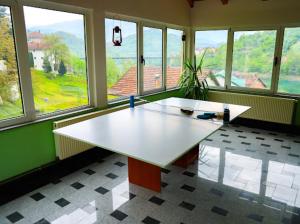 a large white table in a room with windows at Apartman AS na jezeru in Konjic