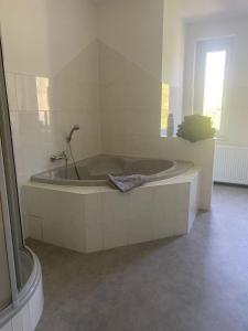 a white bath tub in a bathroom with a window at Heisenberg 4 Personen Familienfreundlich in Markranstädt +19 photos