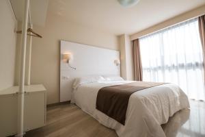 een slaapkamer met een bed en een groot raam bij Apartaments Peronel.la in Lleida