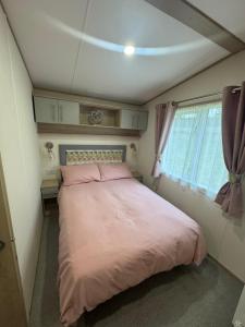 a large bed in a small room with a window at Wallows Lodge with private hot tub in St Austell +36 photos