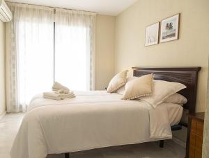a bedroom with a large bed with white sheets and pillows at Costa Azul 5 L in La Manga del Mar Menor +107 photos