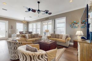 a living room with couches and a tv at Shore to Please in Dauphin Island