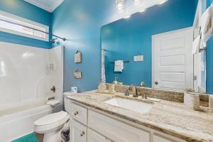 a bathroom with a sink and a toilet and a mirror at Shore to Please in Dauphin Island +17 photos
