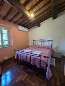 ein Schlafzimmer mit einem großen Bett in einem Zimmer mit Holzböden in der Unterkunft Leonina Country House by Francigena Apartments in Casetta