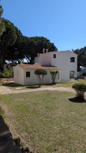 a white building with trees in front of it at Casa da Aldeia in Olhos de Água