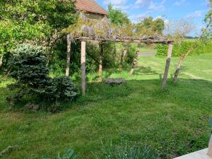 a pergola in the middle of a yard at La Maison aux Roses in Vaux-en Couhé