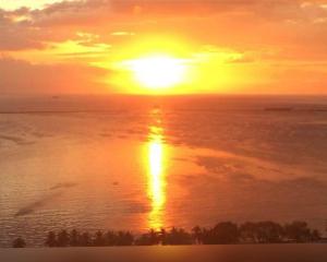 a sunset over the ocean with the sun in the sky at STAYLUXIA MANILABAYVIEW - FEATURING 1 - 5 BEDROOM SUITES WITH BALCONY POOL BAYVIEWS NETFLIX - Housekeeping Available- in Manila