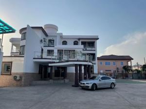 a white car parked in front of a building at JD Hotel in Accra