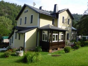 ein Haus mit einer abgeschirmten Veranda im Hof in der Unterkunft Apartment Leucht in Ziegenrück