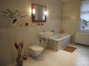 a bathroom with a sink and a toilet and a bath tub at Apartment Leucht in Ziegenrück