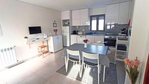 a kitchen with a table and chairs in a room at Casa da Laija - Vistas rio, campo e montanha in Cova