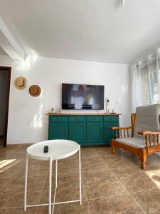 ein Wohnzimmer mit einem grünen Schrank und einem Fernseher in der Unterkunft Balears Relax Apartment in Puerto de Gandía