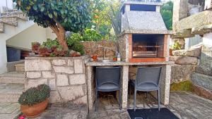 an outdoor kitchen with two chairs and a sink at Casa da Laija - Vistas rio, campo e montanha in Cova