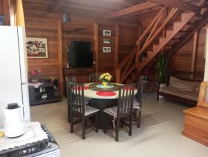 a dining room with a table with chairs and a tv at Paraíso das montanhas in São Bonifácio +7 photos