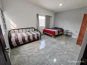 a bedroom with two beds and a couch in it at Casa Frida Yautepec Morelos in Yautepec