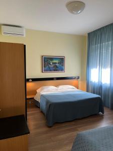 a bedroom with a large bed with a blue blanket at Hotel La Terrazza in Porto San Giorgio +126 photos