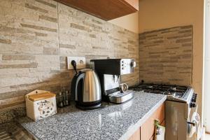a kitchen counter with a coffee maker and a stove at Casa Pinheiro in Pinheiro de Coja +15 photos
